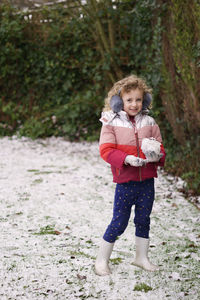 Portrait of a smiling girl standing outdoors in snow