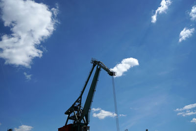 Low angle view of crane against blue sky