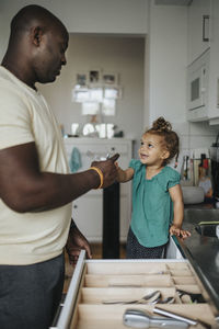 Happy girl helping father in kitchen