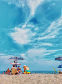 Deck chairs on beach against blue sky