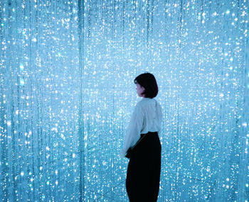 Rear view of man looking at camera over blue background