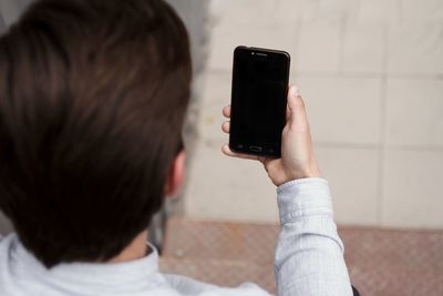 Rear view of man using mobile phone