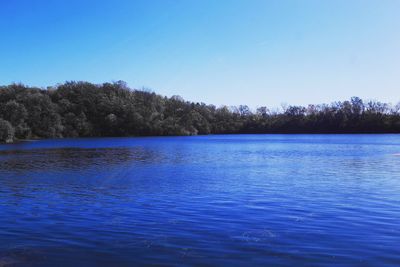 Scenic view of lake against clear blue sky