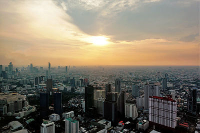 Aerial view of modern buildings against sky during sunset