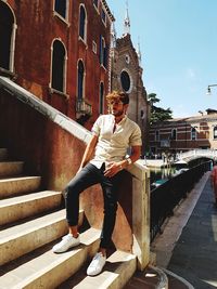 Full length portrait of young man standing on steps