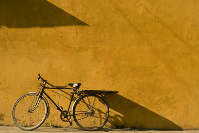 Bicycle leaning on yellow wall at hoi an city in vietnam