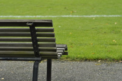 Empty bench on field in park