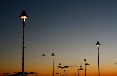 Low angle view of street lights against sky at night