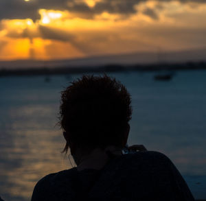 Rear view of man against sky during sunset