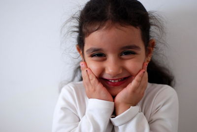 Portrait of smiling girl against wall