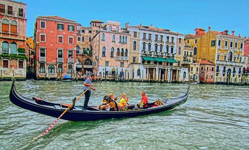 Boats in canal along buildings