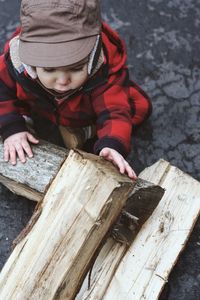 Cute toddler playing with firewood outdoors