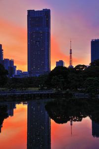 Reflection of buildings in lake during sunset