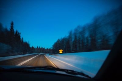 Road seen through car windshield at night