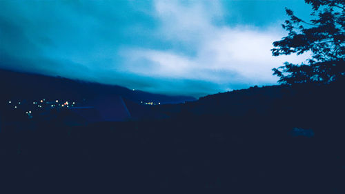 Silhouette trees against sky at night