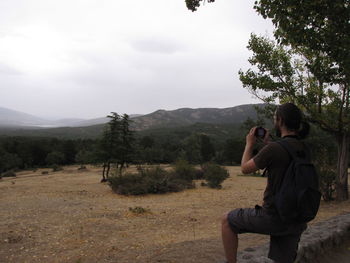 Rear view of man photographing at camera