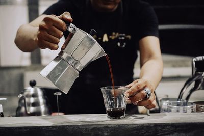 Close-up of man pouring food in glass