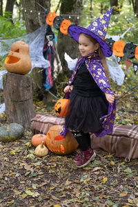 Halloween. cute little girl in witch costume with jack o lantern having fun outdoor