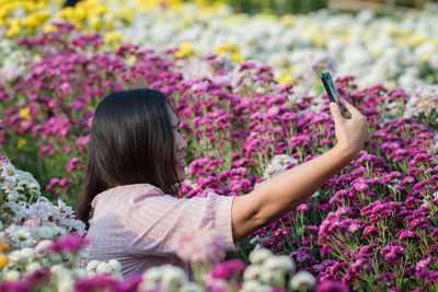 Beautiful woman taking selfie by mobile phone at garden