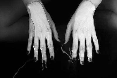 Close-up of human hand against black background