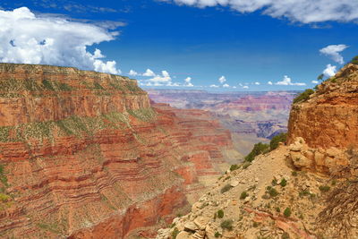 Rock formations on landscape against cloudy sky