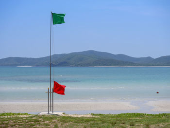 Flag on beach against sky