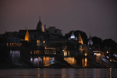 Illuminated buildings against sky at night