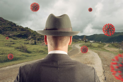 Rear view of man with red umbrella against sky