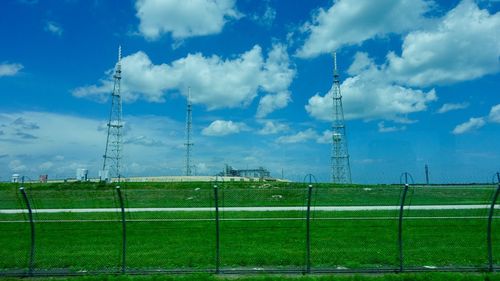 Electricity pylon on field against sky