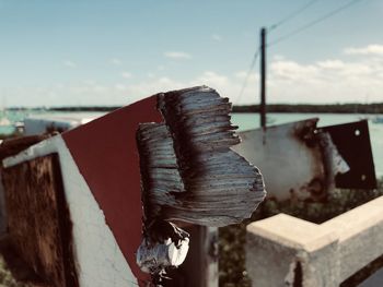 Close-up of broken toll bridge against sky