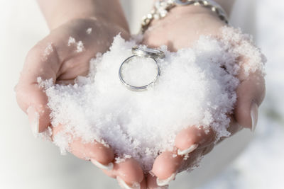 Close-up of hand holding snow and ring
