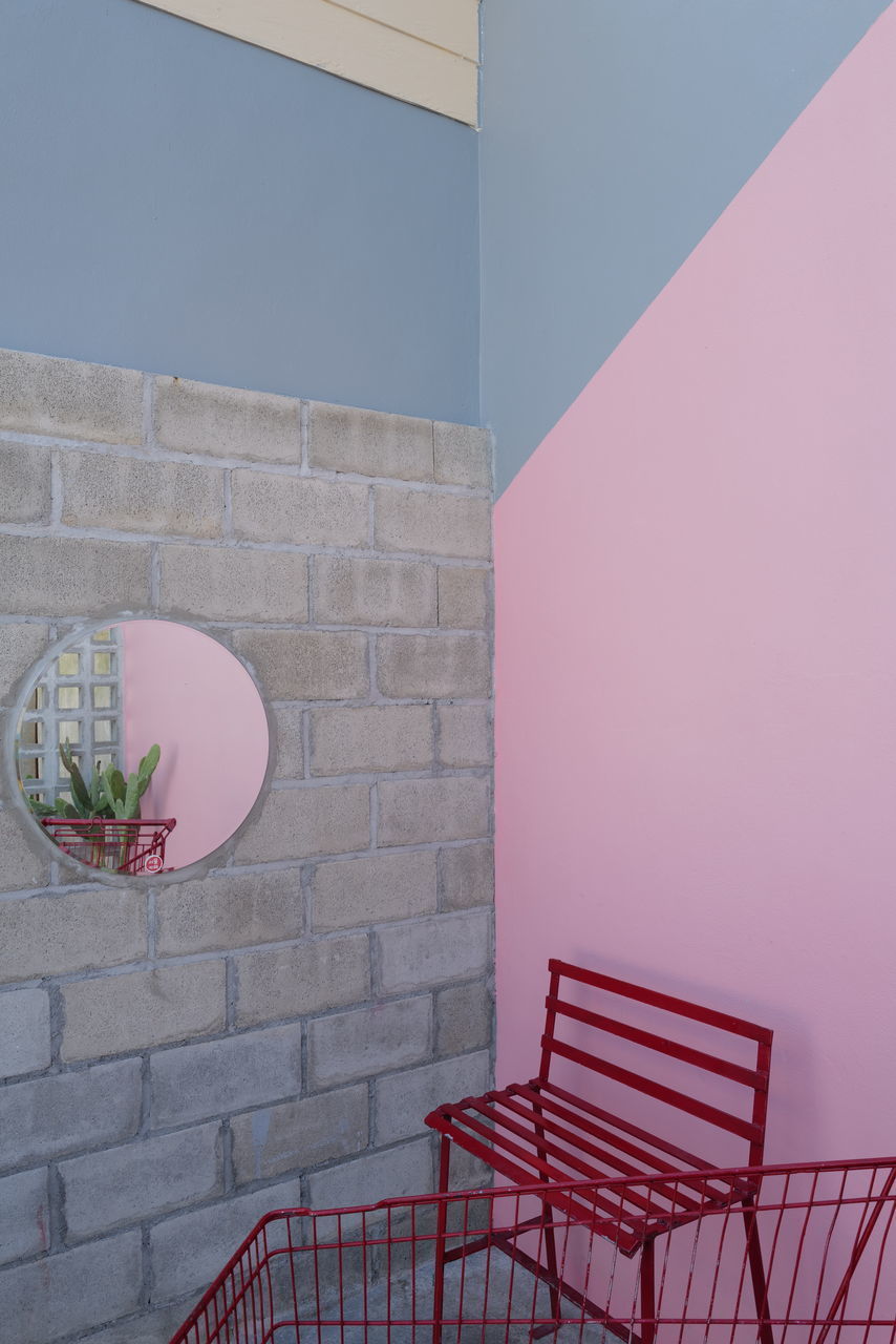 PINK UMBRELLA ON WALL AGAINST BUILDING