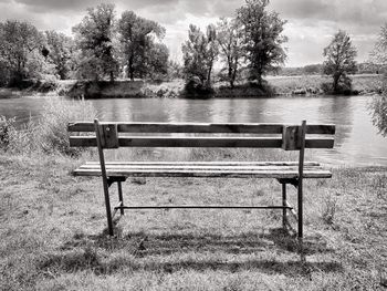 Empty bench by lake in park