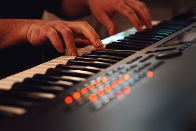 Cropped hands of man playing piano