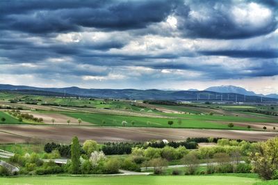 Scenic view of grassy field against cloudy sky