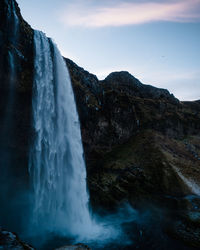 Scenic view of waterfall against sky