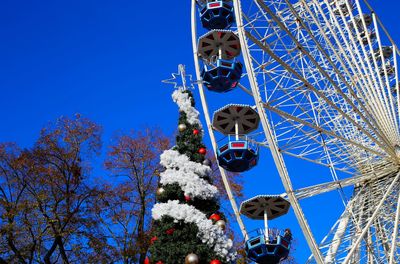 Low angle view of ferris wheel against blue sky