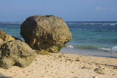 Rocks on beach against clear sky