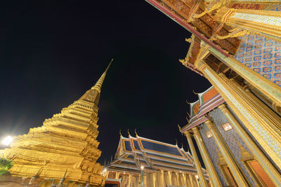 Low angle view of illuminated buildings against sky at night