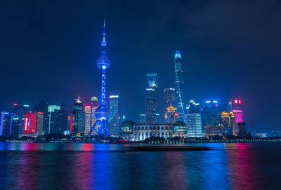 River against illuminated oriental pearl tower in city at night