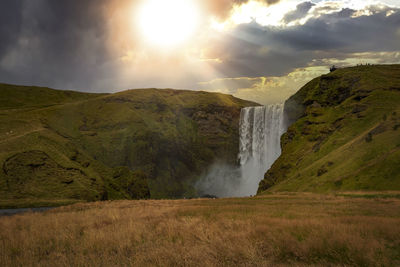 Scenic view of waterfall against sky