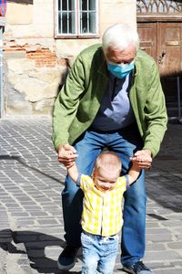 Rear view of father and son on sidewalk