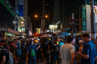 People walking on city street at night