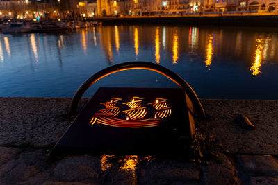 Detail of an illuminated mooring in the old harbor of la rochelle at night. blurred city lights