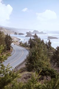 High angle view of road amidst trees against sky