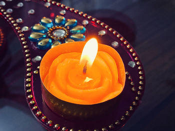 High angle view of illuminated tea light candle on table