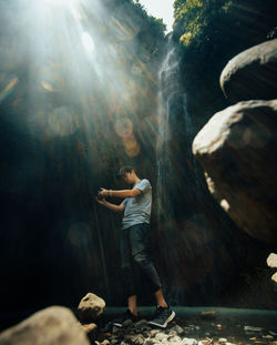 Rear view of woman standing on rock
