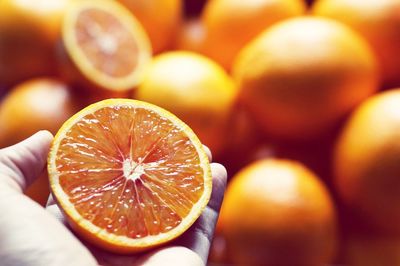 Close-up of hand holding orange