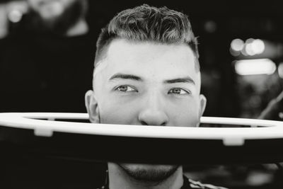 Close-up portrait of young man holding camera