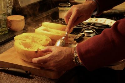 Cropped image of hand preparing food in kitchen